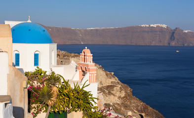 Iconic church with blue cupola and pink bell tower in Oia, Santo