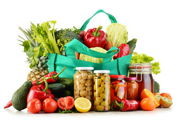 Green shopping bag with groceries isolated on white