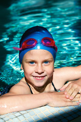 child - swimmer swims in a swimming pool