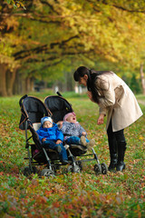 mother with children twins on a walk in the autumn park