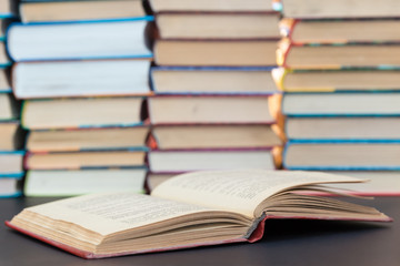 Opened red book on a background of a pile of books
