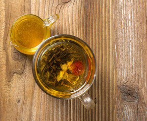 Teapot with tea on wooden background