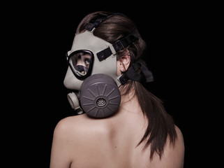 Beautiful girl wearing gas mask and looking aside