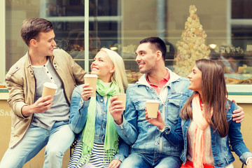 group of smiling friends with take away coffee