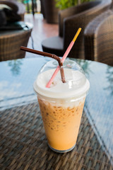 Iced coffee with straw and in plastic cup