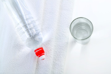 Bottle of water and round towel on white background