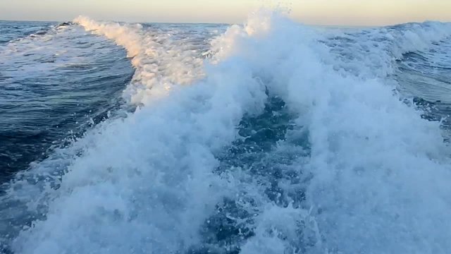 View of ocean from moving motor yacht with wake