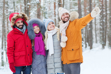 group of smiling men and women in winter forest