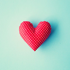 Red patterned cotton heart over blue background