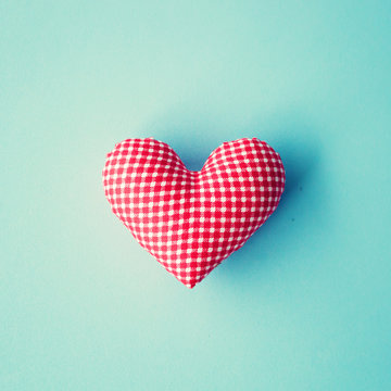 Red patterned cotton heart over blue background