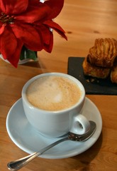 Cup of cappuccino and small pizza on the table