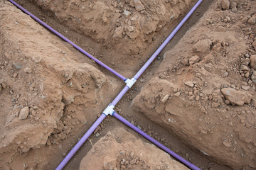 Irrigation pipe in dirt trenches for sprinkler system - obrazy, fototapety, plakaty