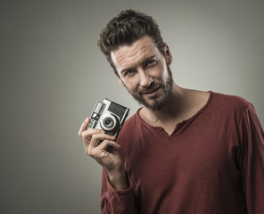 Young man taking pictures with a vintage camera