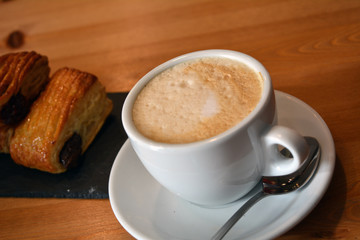Cup of cappuccino and small pizza on the table