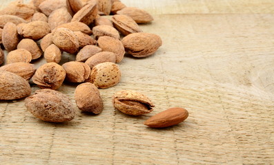 Group of almonds with shell on wooden plank,board