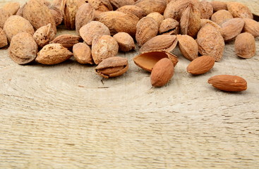 Group of almonds with shell on wooden plank,board