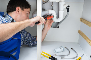 Plumber Fixing Sink In Bathroom