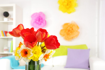 Beautiful spring flowers in vase on home interior background