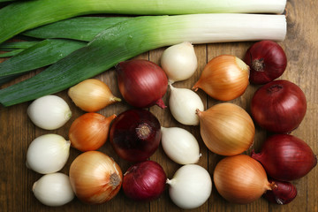 Different raw onion on wooden background