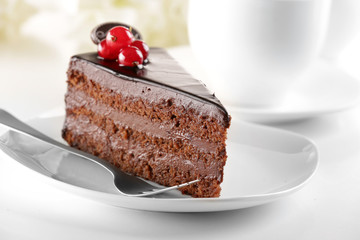 Delicious chocolate cake on plate on table on light background