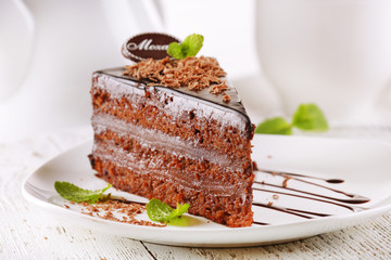 Delicious chocolate cake on plate on table on light background