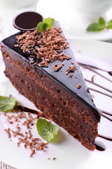 Delicious chocolate cake on plate on table on light background
