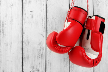 Pair of boxing gloves on color wooden background