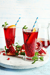 Pomegranate drink in glasses with mint and slices of orange