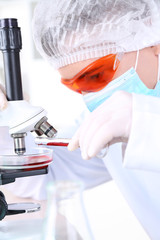 Male scientist using microscope in laboratory