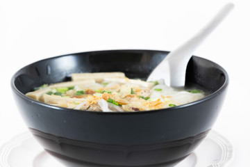 Bowl of Vietnamese pho bo,noodle soup served with onions and cil