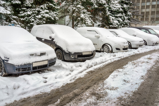 an image of snow covered cars in parking lot