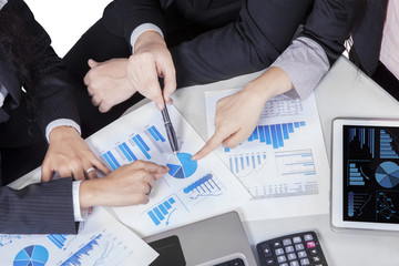 Business team hands pointing pie chart