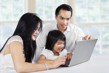 Happy family browsing internet with laptop