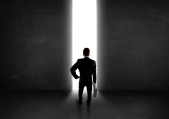 Obraz premium Business person looking at wall with light tunnel opening