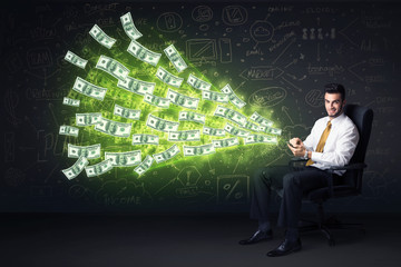 Businessman sitting in chair holding tablet with dollar bills co