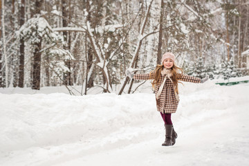 Fototapeta na wymiar Girl happily runs in winter woods