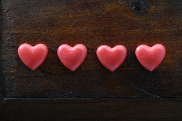 Fototapeta na wymiar Four red heart on wooden background