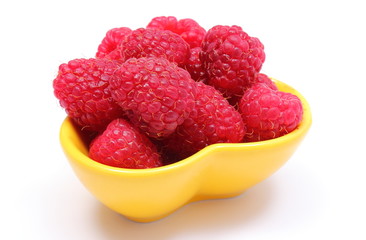 Fresh raspberries in yellow bowl on white background