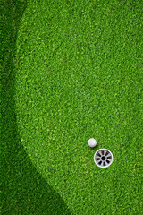 The ball at the hole on the golf course