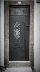 Metal door with patterns on the stone wall. Toned