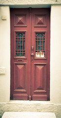 Old red wooden door with window and grid. Toned