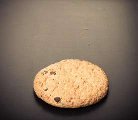 Oat cookie on the old black shabby background. Toned