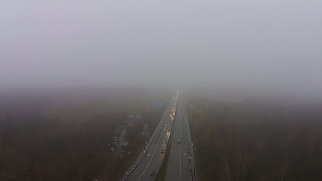 Flying over the highway in the fog, traffic in the fog