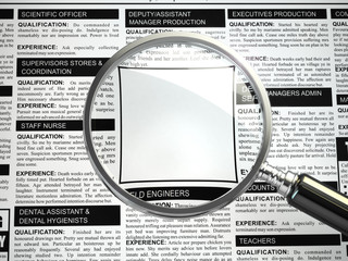 Job search concept. Loupe, newspaper with employment advertiseme