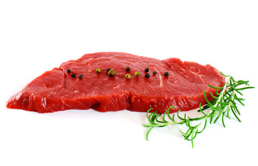 Piece of fresh raw meat with pepper, rosemary over white