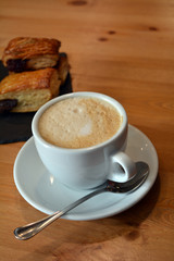 Cappuccino and small pizza on the table