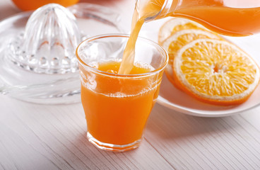 succo di arancia versato nel bicchiere di vetro
