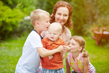 Fototapeta premium Familie mit Baby und Kindern im Garten