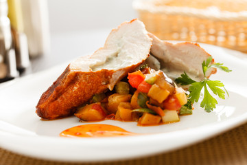 stuffed pork tenderloin roulade garnished with vegetables