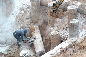 Construction site, laborer sawing wood
